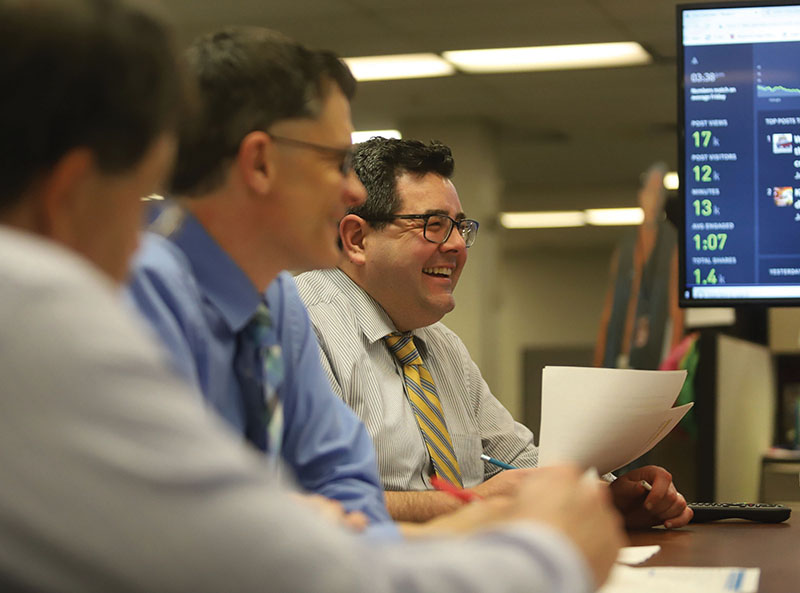 Parse.ly analytics displayed on a computer monitor with three smiling men looking at the data.