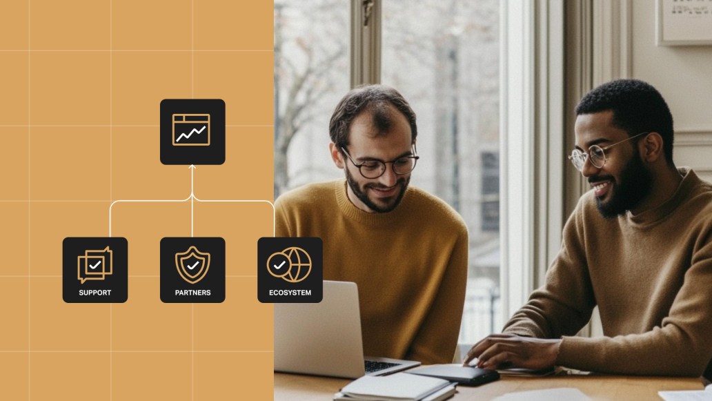 Two colleagues in matching brown sweaters are collaborating over a laptop at a table near a window. In the left corner of the image, icons representing support, partners, and digital ecosystem are connected with lines, symbolizing the integrated approach WordPress VIP uses to drive high site performance.